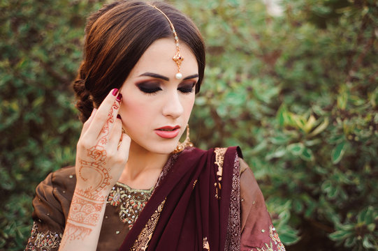 Mehendi on the hands of girls, Woman Hands with brown mehndi tattoo. Hands of Indian bride girl with brown henna tattoos.