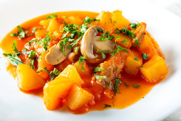 Stew made from potatoes, mushrroms and herbs boiled in tomato sauce