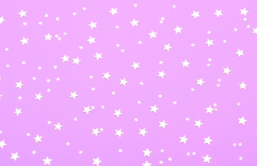 Christmas pattern made of silver stars on pink background. Winter concept. Flat lay.