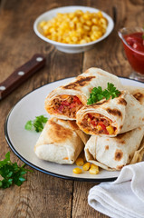 Burrito with ground beef and vegetables on a plate