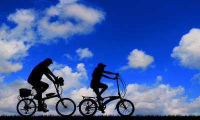 Fototapeta na wymiar Silhouette group friend and bike relaxing on blurry sky background