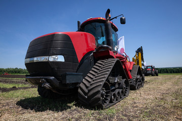 heavy red tractor at agricultural exhibition in motion