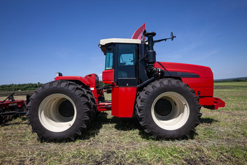 heavy red tractor at agricultural exhibition in motion