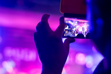 the person registers the night life by creating a movie using the camera built into the smartphone