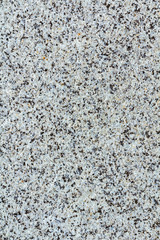 Vertical image of texture gray granite. Smooth light stone texture. Gray colors. Gray stone with dark inclusions. Material for decoration, background texture, interior design. Uniform surface interspe