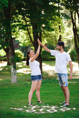A young couple celebrate victory playing tic-tac-toe in the park