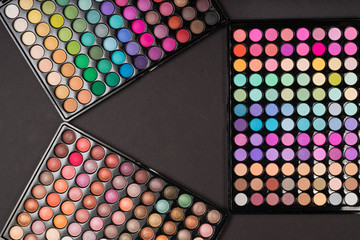 Above view of eyeshadow palettes as a colorful make-up background
