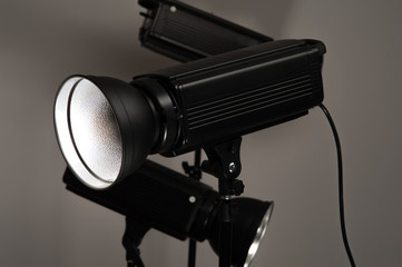 Group of professional black studio illuminators on a grey background. Photo studio equipment concept