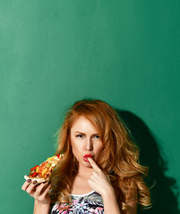 Young beautiful woman hold big slice of stuff mexican vegetable pizza slice lick one finger tasty sign on green