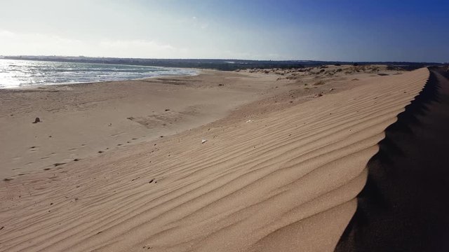 Landscape of the beach with sand dunes in the right corner of the video. Calm sea. Mediterranean sea seen from Sampieri - Italy.