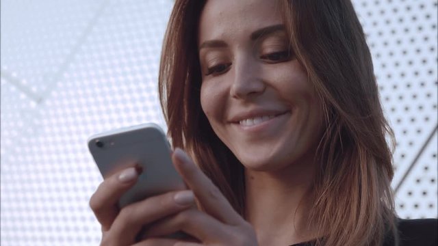 Close-up potrait happy and in love girl typing in the phone and smile