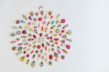 Many colorful new year toys lying on white background in shape of Christmas bauble, top view, flat lay. Creative composition, winter holiday concept, greeting card with copy space