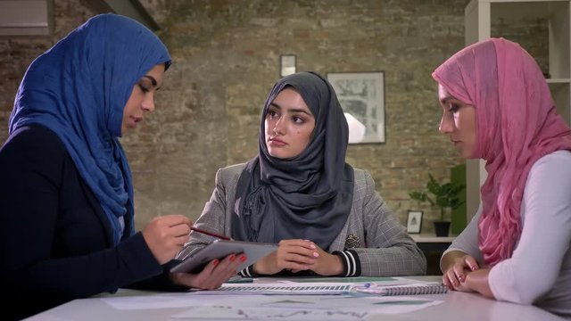 Three arab hijab girls are sitting all together at big teble and talking with patients about work, office illustration