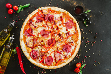 Delicious classic meat pizza on black background