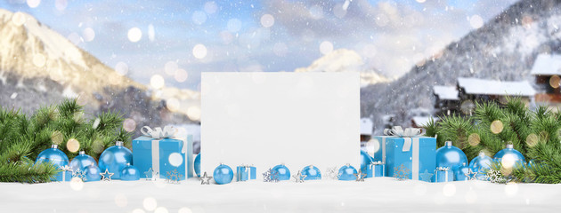 Blank Christmas card laying on blue baubles and gift 3D rendering