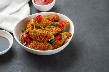 Chicken nuggets with sauce and pepper on a dark background. Copy space.