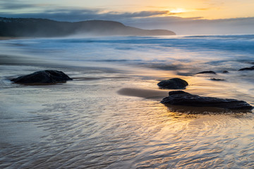 Fototapeta na wymiar Sunrise at Kilcare Beach,Ausralia. Reflections, waves sand on the Central Coast, New South Wales