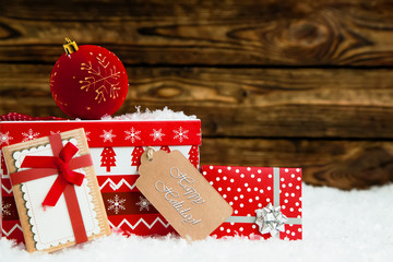Christmas box and small gift on snow and wooden background
