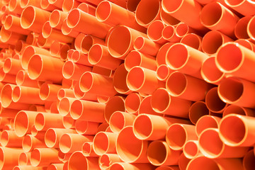 orange PVC pipes stacked in construction site