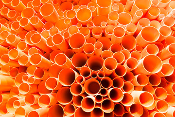 orange PVC pipes stacked in construction site