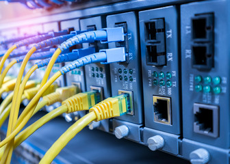 Fiber Optic cables connected to an optic ports and Network cables connected to ethernet ports