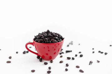 Fototapeta na wymiar Red coffee cup empty with coffee beans. On a red plate. Coffee break