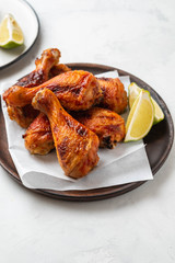 Chicken legs with sauce, rosemary and lime on a white background. Copy space.