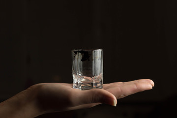Hand holding a glass on blackbackground