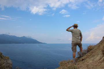 Man with straw hat enjoying the view in Elba island, Enfola headland, Italy