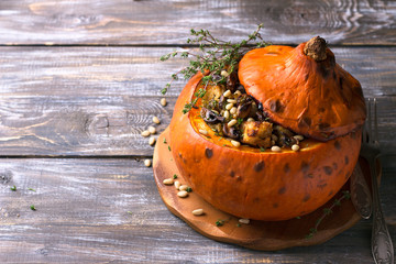 Pumpkin stuffed with crunchy croutons, mushrooms, leek and celery with thyme and pine nuts on a...