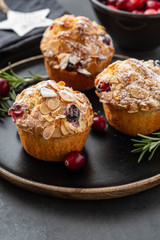 Muffins, cakes with cranberry, rosemary and almond nuts. Christmas decoration. Copy space.
