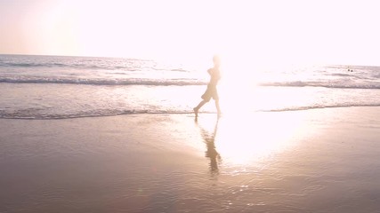 Slow motion - A child 3-5 years old running freely while the camera chase him and he laughs, in a sunny day in the beach 