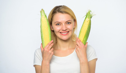 Woman hold yellow corn cob on white background. Girl playful mood hold ripe corns in hands. Food vegetarian and healthy natural organic product. Cook corn recipe. Vegetarian nutrition concept