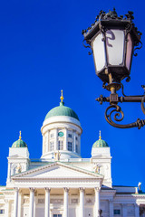 Fototapeta na wymiar Element of street lamp and dome of Helsinki Cathedral (St Nicholas' Church) on Senate Square, Helsinki, Finland