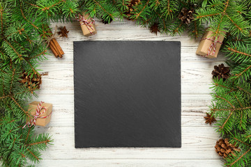 top view. Empty black slate square plate on wooden christmas background. holiday dinner dish...