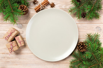 Empty white matte plate on wooden background with christmas decoration, Round dish. New Year concept