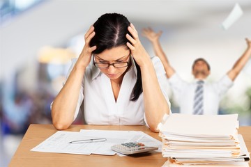 Young businessman with stack of papers on background