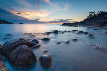 Fototapeta na wymiar Sleepy Bay, Freycinet National Park, Tasmania. Sunrise over rock formations, long exposure.