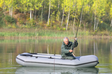 An elderly fisherman just caught a fish