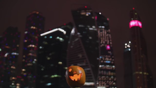 Night city light skyscrapers and halloween pumpkins
