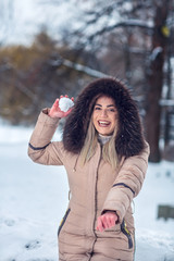 Winter concept. Happy woman playing snowball fight on the snow day. .