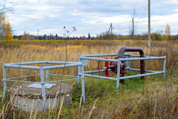 Obraz na płótnie Canvas Pipe and a red valve pipe near oil pump jacks.