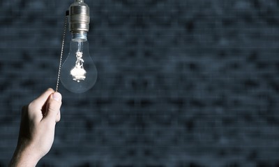 Hand turning off the bulb lamp.Turning off the light.