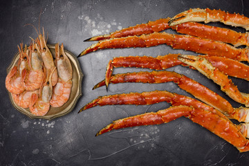 King Crab claw with shrimps on black background