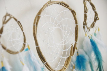 Fototapeta na wymiar Photo of handmade dreamcatcher with feathers and beads on a white background, ethnic theme