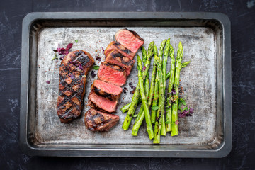 Traditionelles gegrilltes dry aged Roastbeef mit grünen Spargel als Draufsicht auf einem alten...