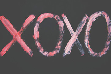 inscription on a black background pink colors xoxo