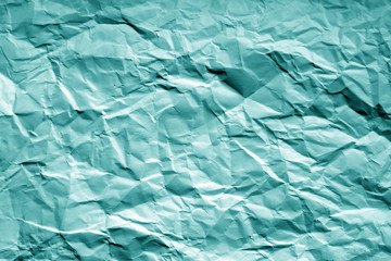 Crumpled sheet of paper with blur effect in cyan tone.