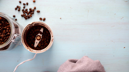 Młynek do kawy z rozrzuconymi ziarnami kawy