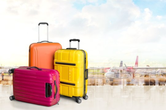 Colorful Suitcases And Backpack On Wall Background